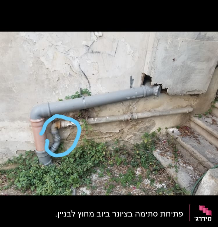 צינור מתכת עם חיבורי פלסטיק על קיר חיצוני